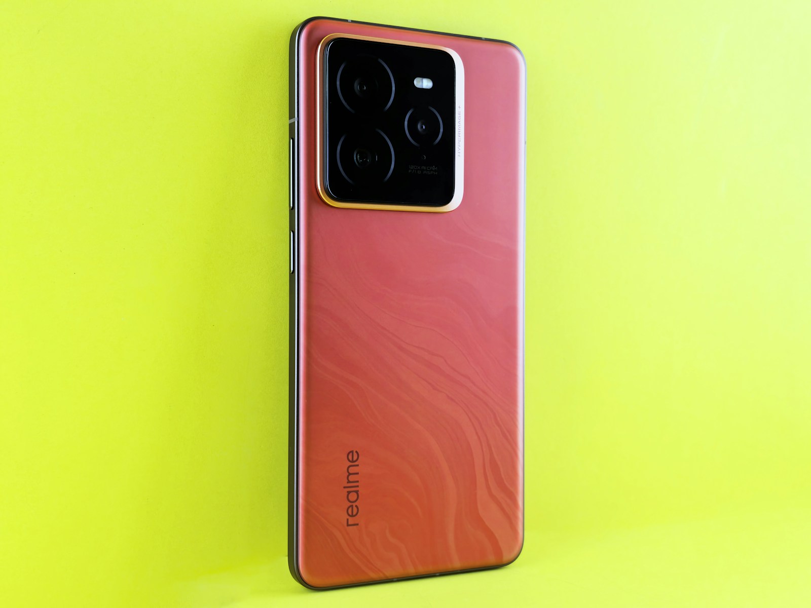 Red smartphone with camera array on yellow background