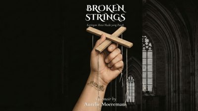 Sampul buku Broken Strings karya Aurelie Moeremans menampilkan tangan dengan tato bertuliskan Aurelie yang memegang kayu pengendali boneka tali yang putus.