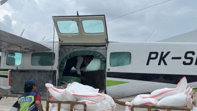 Petugas memuat karung putih berisi bahan semai (seperti garam NaCl) ke dalam pesawat baling-baling PK-SCJ di landasan pacu, sebagai persiapan operasi modifikasi cuaca untuk mencegah banjir di Jawa Tengah selama puncak musim hujan.