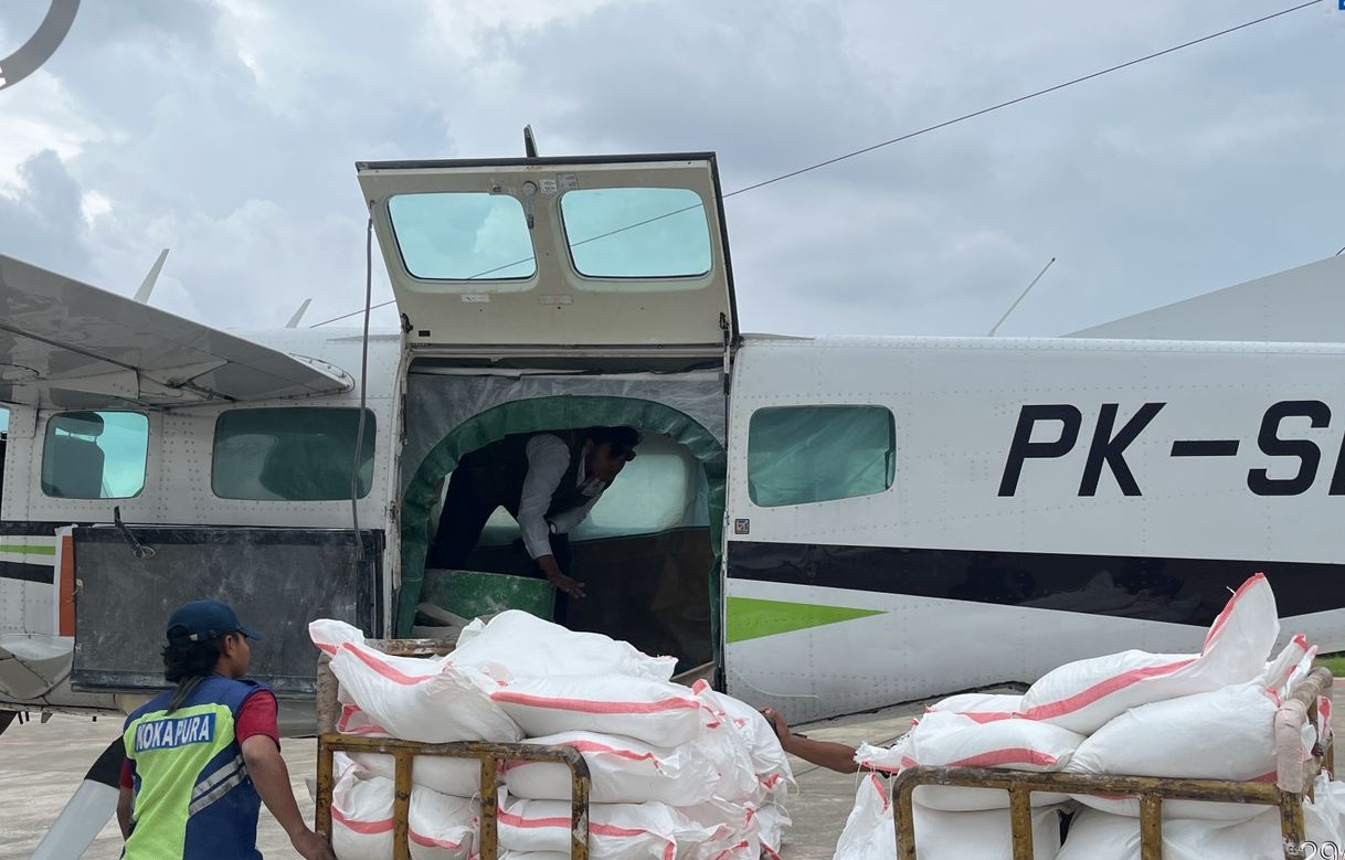 Petugas memuat karung putih berisi bahan semai (seperti garam NaCl) ke dalam pesawat baling-baling PK-SCJ di landasan pacu, sebagai persiapan operasi modifikasi cuaca untuk mencegah banjir di Jawa Tengah selama puncak musim hujan.