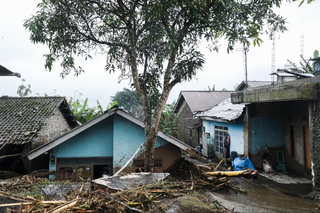 Tumpukan batang kayu besar, puing bangunan seng, dan material lumpur sisa banjir bandang yang menghancurkan area di Desa Penakir, Pemalang.