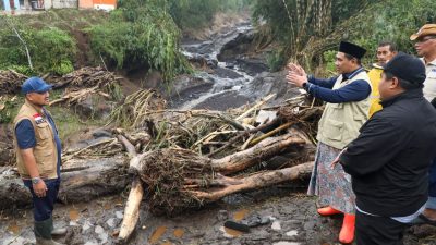 Wakil Gubernur Jawa Tengah Taj Yasin Maimoen (berpeci hitam dan rompi krem) sedang berdiskusi di tengah lokasi bencana banjir bandang yang penuh lumpur dan kayu gelondongan di Pemalang.