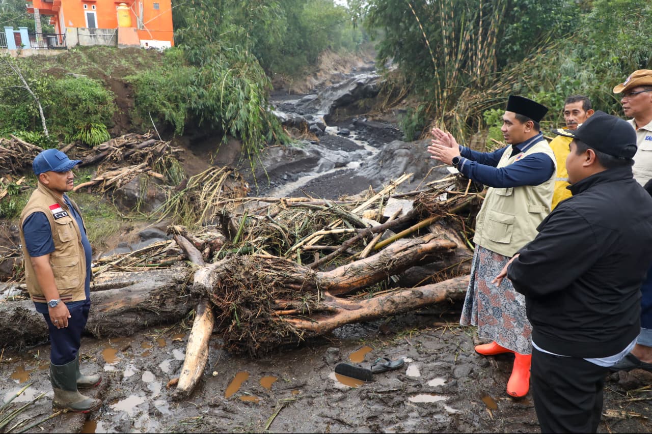 Wakil Gubernur Jawa Tengah Taj Yasin Maimoen (berpeci hitam dan rompi krem) sedang berdiskusi di tengah lokasi bencana banjir bandang yang penuh lumpur dan kayu gelondongan di Pemalang.
