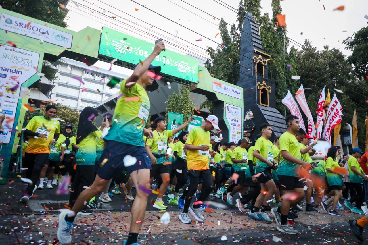 Suasana meriah di garis start Sriboga Run di Semarang, dengan konfeti yang berterbangan dan gapura besar yang menjadi latar belakang peserta yang baru memulai lari.