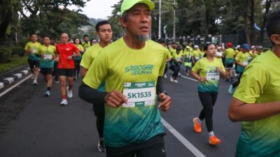 Seorang pria berjanggut dengan topi hijau dan nomor dada 5K1535 tampak fokus saat berlari dalam acara Sriboga Run 2026.