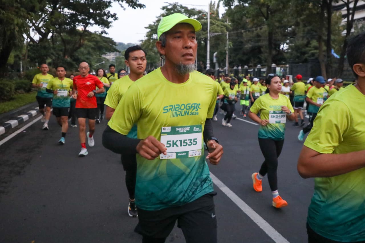 Seorang pria berjanggut dengan topi hijau dan nomor dada 5K1535 tampak fokus saat berlari dalam acara Sriboga Run 2026.