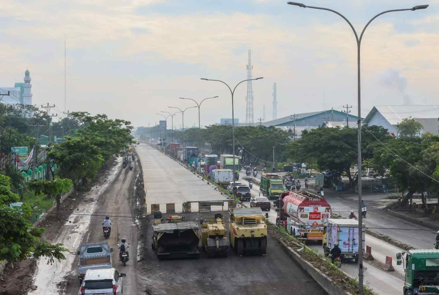 Pekerja melakukan perbaikan dan penambalan aspal di Jalur Mudik Jawa Tengah kawasan Pantura untuk persiapan Lebaran 2026.