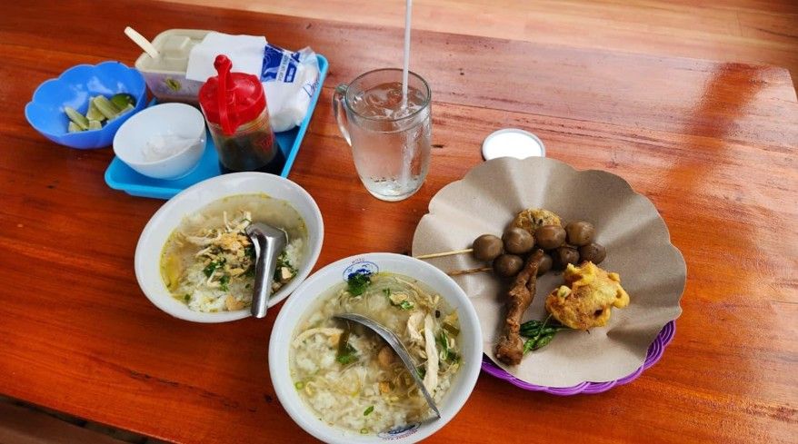 Semangkuk soto hangat di meja bambu dengan latar belakang hamparan sawah hijau asri di Saung Soto Mewah Semarang.