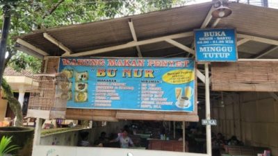 ampak depan Warung Omelet Bakar Bu Nur Tembalang dengan spanduk biru dan sangkar perkutut yang ikonik.