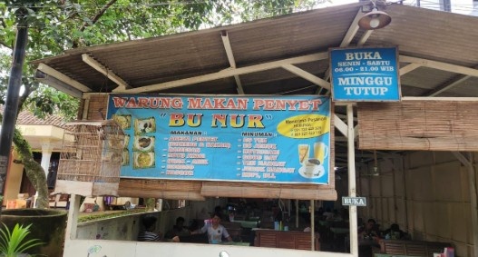 ampak depan Warung Omelet Bakar Bu Nur Tembalang dengan spanduk biru dan sangkar perkutut yang ikonik.