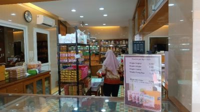 Interior toko wingko babat Semarang cap kereta api dengan pengunjung memilih oleh-oleh khas Semarang