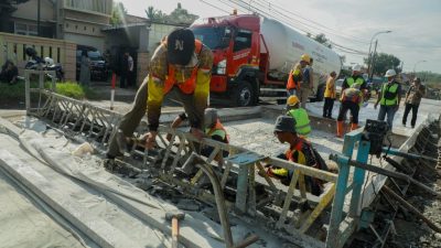 Pekerja Dinas PUPR Jawa Tengah sedang memperbaiki jalan provinsi yang rusak berat menggunakan alat berat pada tahun 2026.