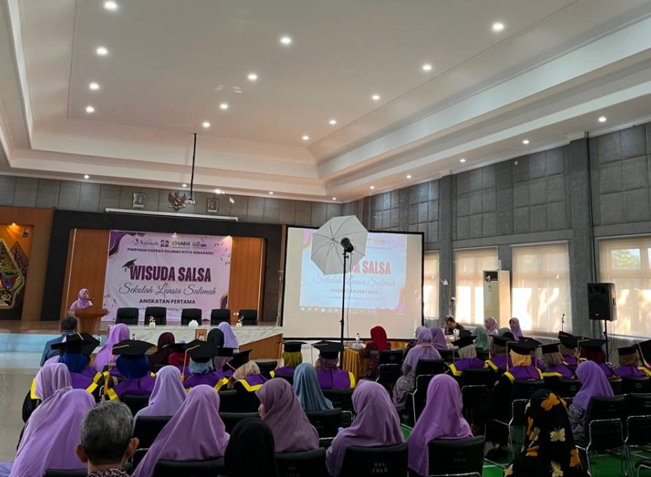 Para wisudawati lansia mengenakan toga tersenyum saat berfoto bersama dalam acara Wisuda Sekolah Lansia Salimah Angkatan I di Aula Kecamatan Tembalang, Semarang.