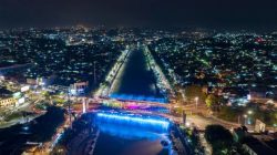 Suasana malam hari di Banjir Kanal Barat Semarang dengan gemerlap lampu taman dan pengunjung di area amfiteater.