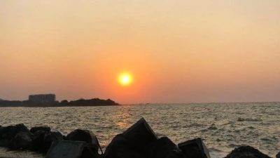 Pengunjung keluarga bersantai menikmati pemandangan senja di area tanggul pemecah ombak Pantai Marina Kota Semarang.