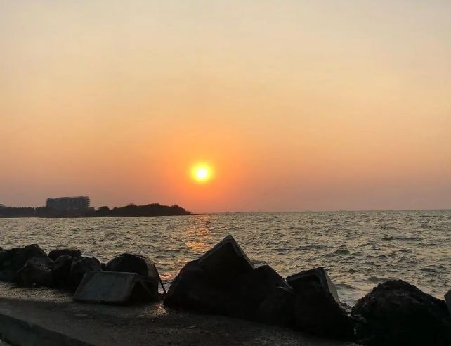 Pengunjung keluarga bersantai menikmati pemandangan senja di area tanggul pemecah ombak Pantai Marina Kota Semarang.
