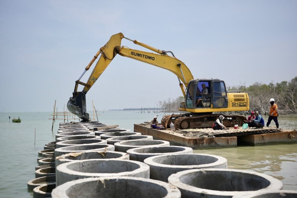 Pekerja menyelesaikan pembangunan tanggul pantai berbasis alam atau hybrid sea wall sepanjang 930 meter di Desa Surodadi, Kecamatan Sayung, Kabupaten Demak.
